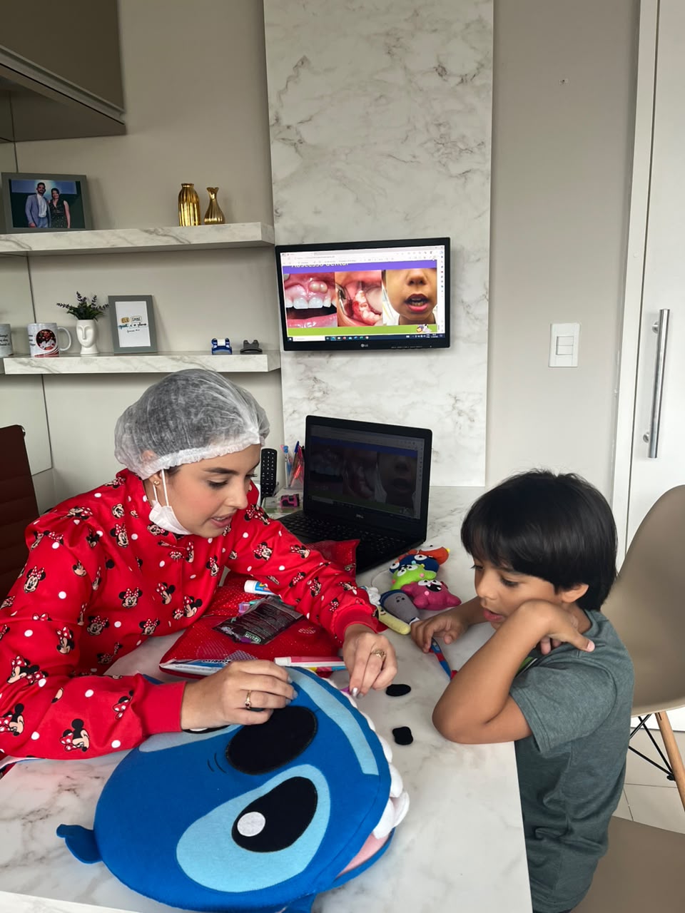 Dra. Thirza Nunes ensinando escovação a um menino com fantoche do Stitch