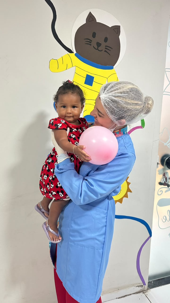 Dra. Thirza Nunes acolhendo um bebê com balão na recepção decorada